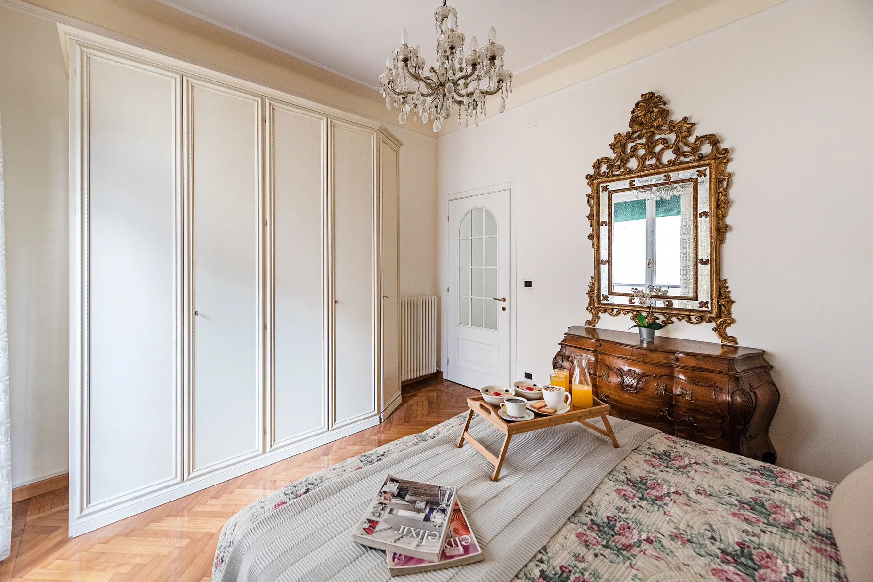 A bedroom with a bed, fitted wardrobes, and a wooden dresser.