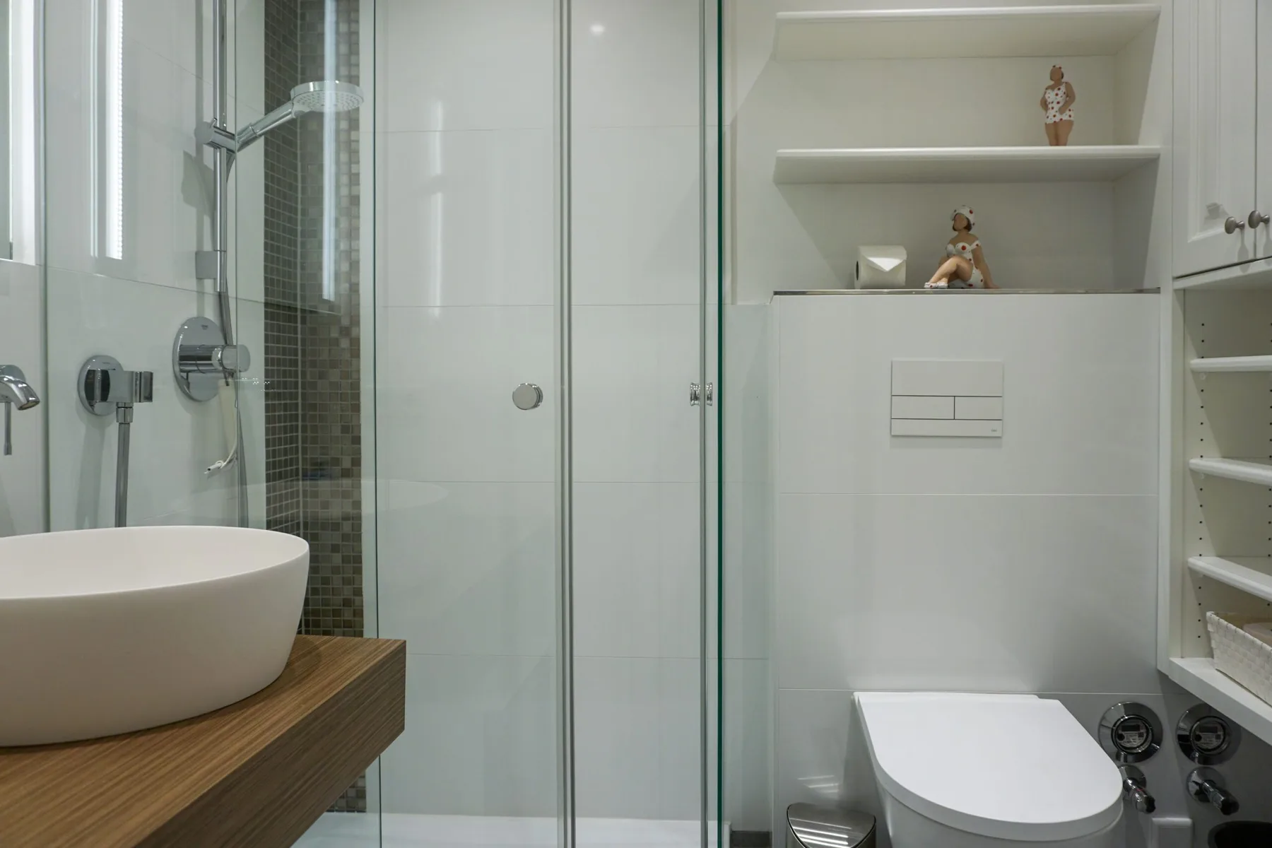 Un baño moderno con ducha de vidrio, lavabo e inodoro.
