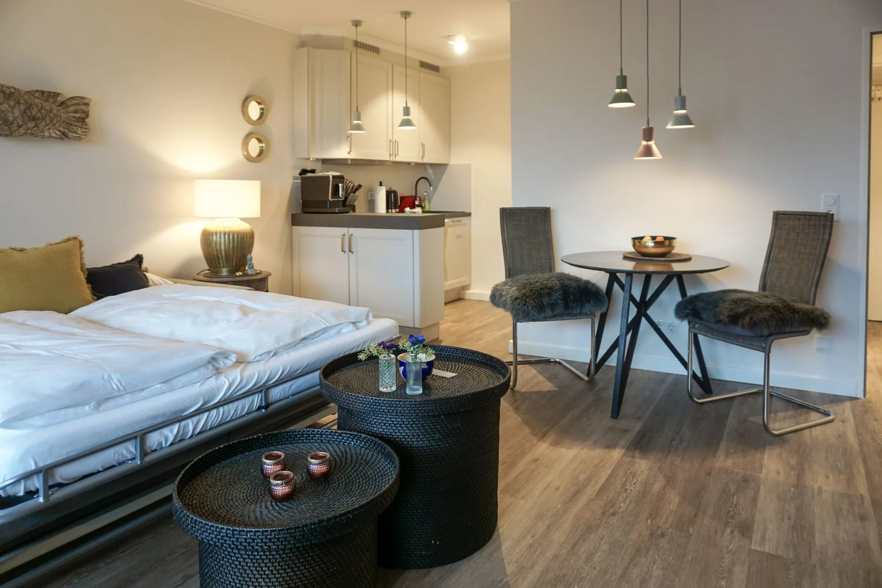 Un dormitorio y un comedor comparten un espacio abierto con una pequeña cocina.