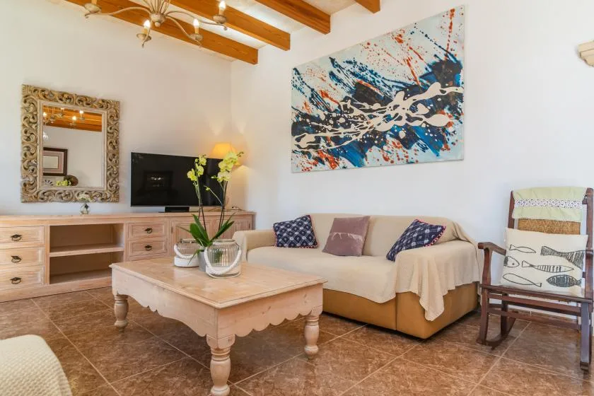 A living room with seating, a coffee table, and colorful abstract wall art.