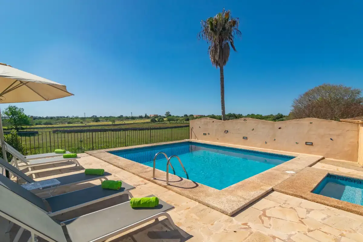 An outdoor pool patio has lounge seating and views of the surrounding fields.