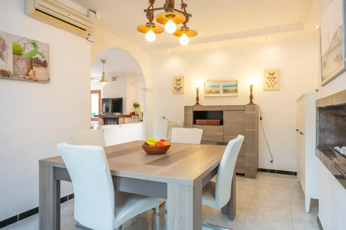 Un comedor con una mesa y sillas junto a una chimenea.