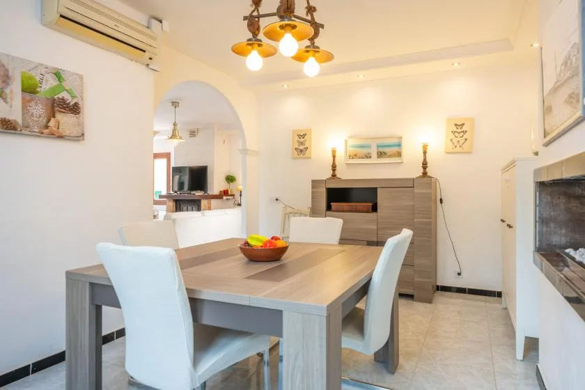 Un comedor luminoso con una mesa y una chimenea al fondo.