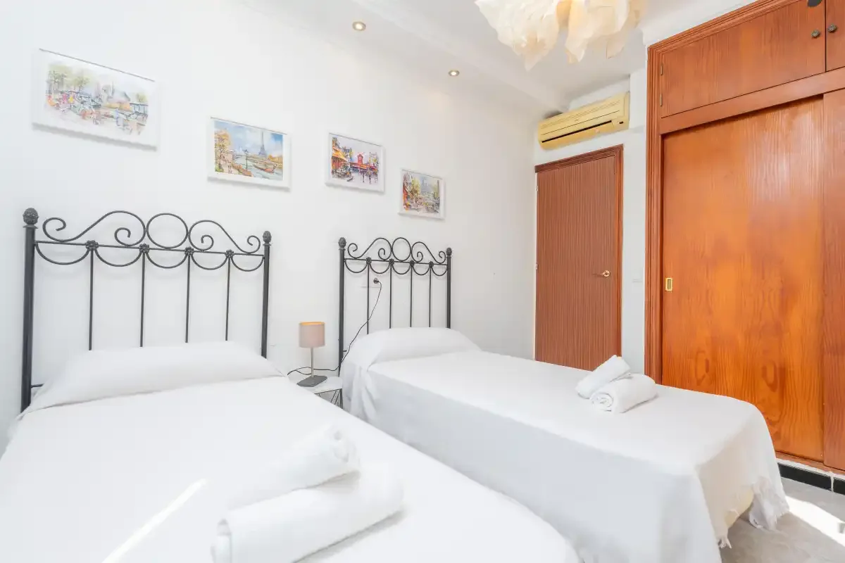 Un dormitorio con dos camas y cuadros enmarcados en la pared.
