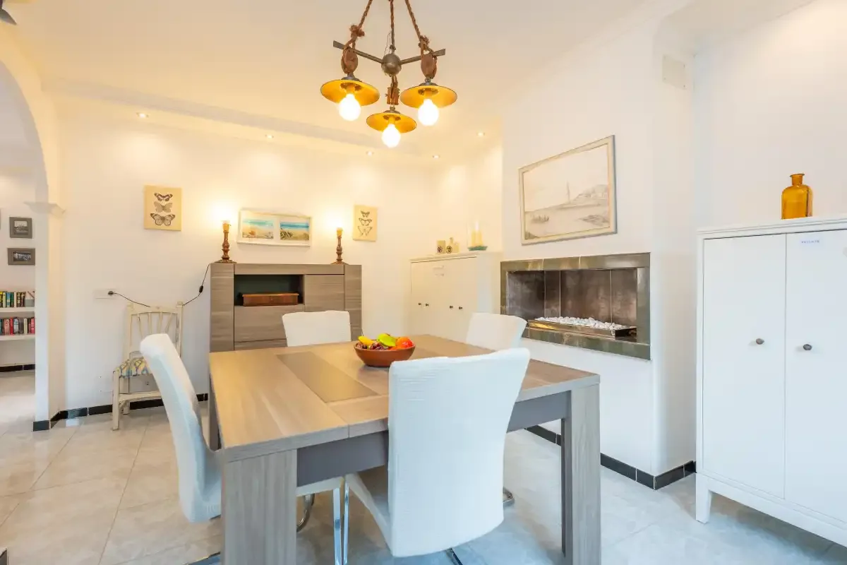 Un comedor con una mesa y sillas junto a una chimenea.