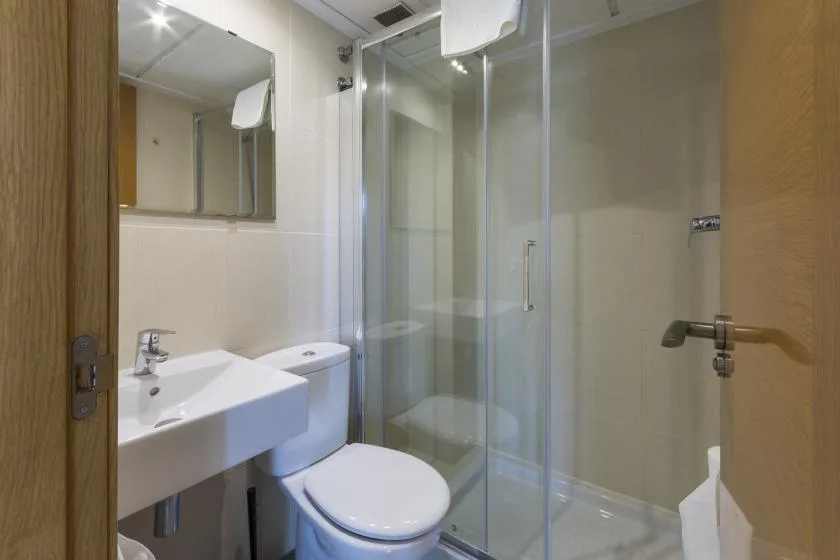 A bathroom with a sink, toilet, and glass shower.
