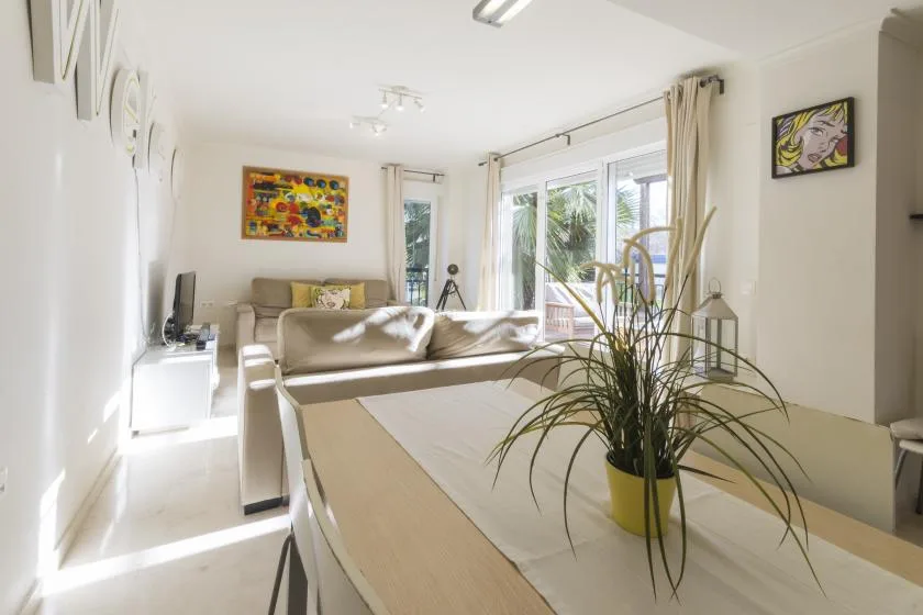 A bright living room with seating, a low table, and large windows.