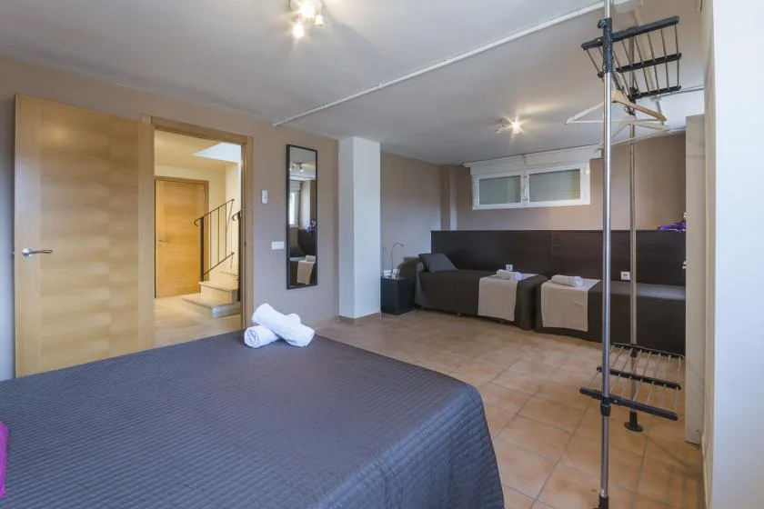 A bedroom with a large bed and a seating area along the back wall.