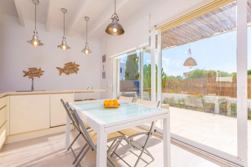 Un comedor luminoso se abre a un patio mediante amplias puertas corredizas de vidrio.