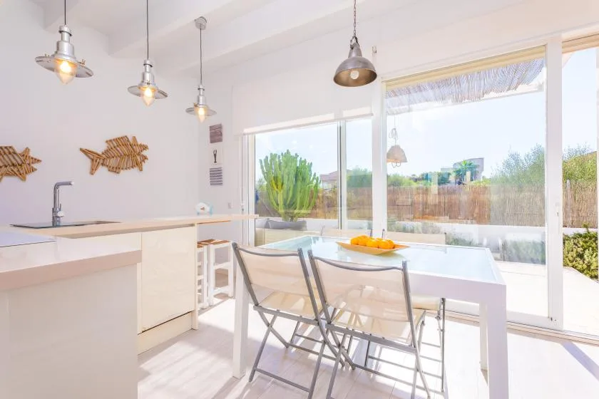 Un comedor luminoso con una mesa junto a grandes ventanas.