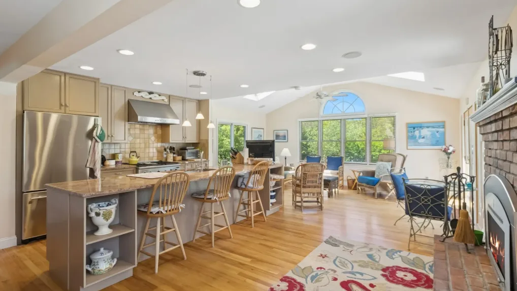 Cocina y comedor de concepto abierto con una zona de estar junto a las ventanas.