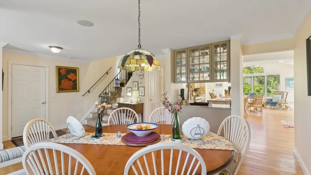 Un comedor con una mesa redonda y sillas está junto a una cocina abierta.