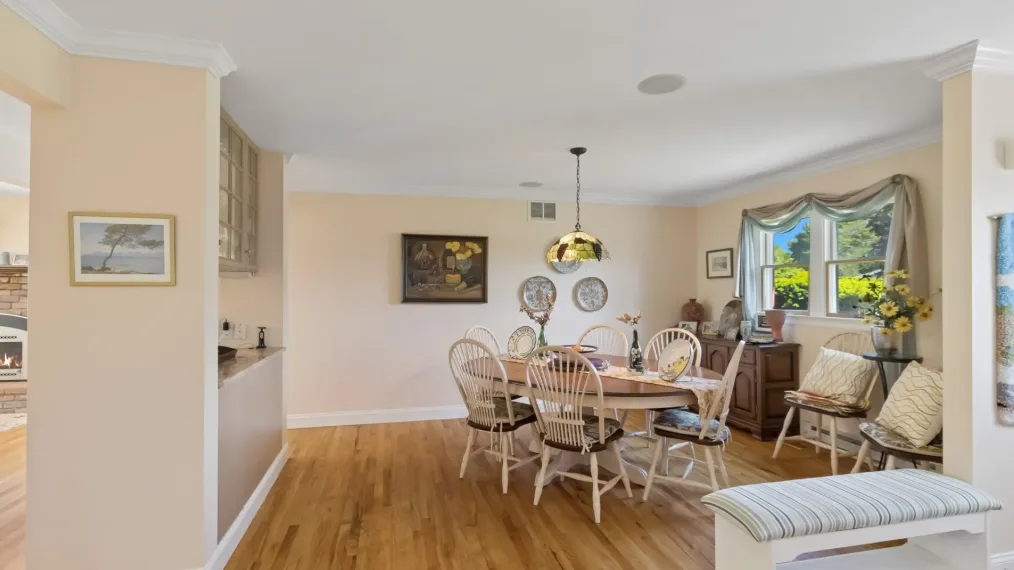 Un comedor con una mesa de madera y asientos junto a una ventana luminosa.