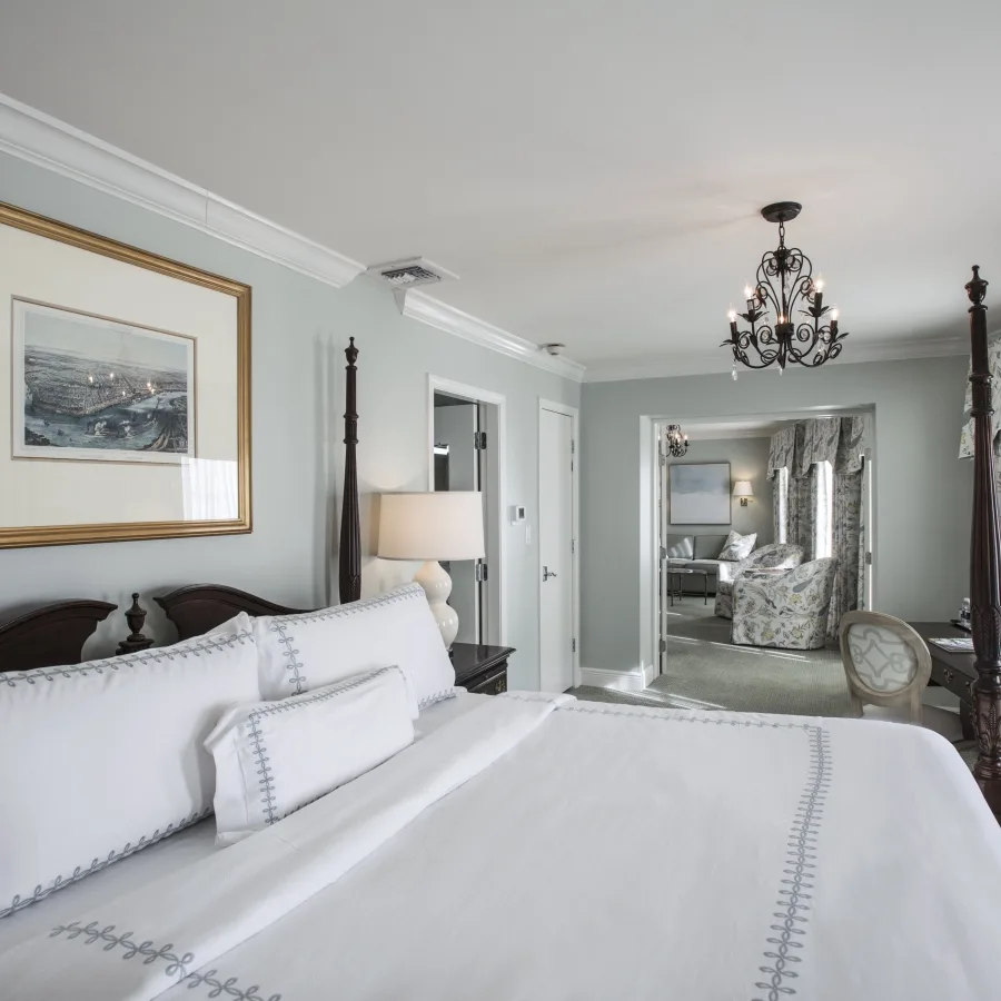 Dormitorio de la suite French Quarter con cama con dosel y vista a la sala de estar.