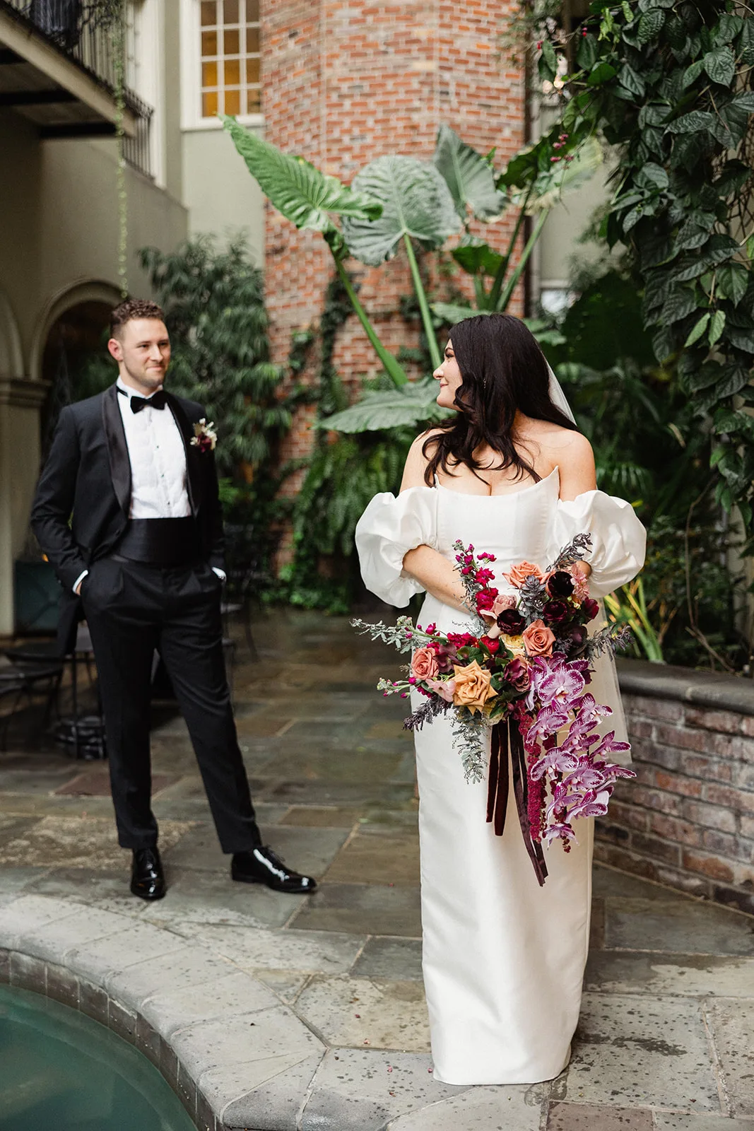 Courtyard pool beside a wedding couple.