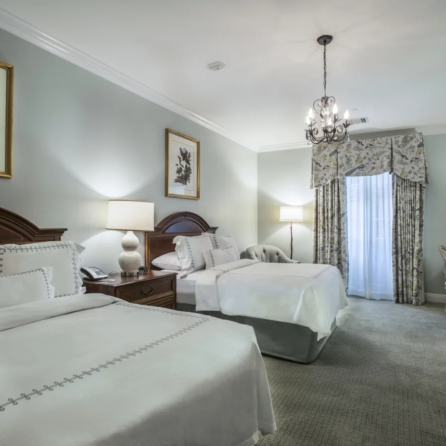 Deluxe Double/Double room with two double beds and a desk.