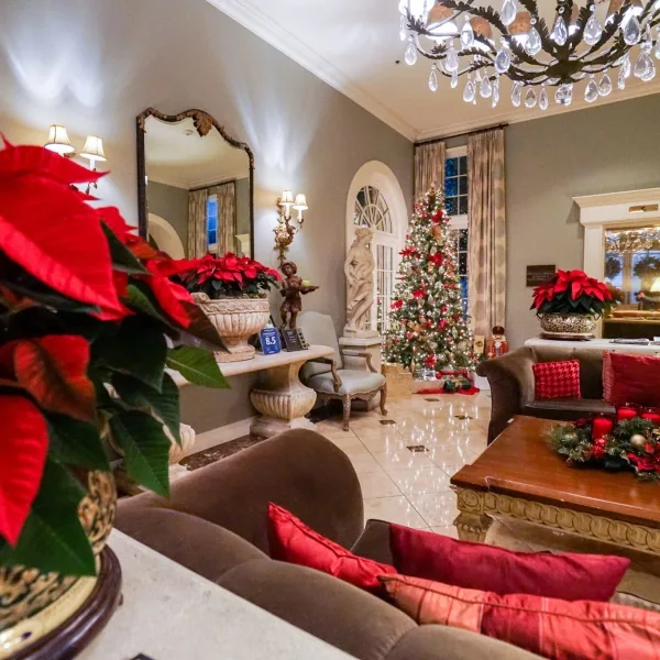 Hotel lobby decorated for Christmas with poinsettias, sofas and a lighted tree.