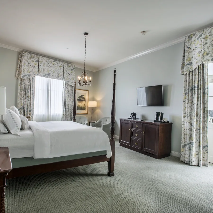 Superior King room with a four-poster bed, patterned curtains and a balcony doorway.