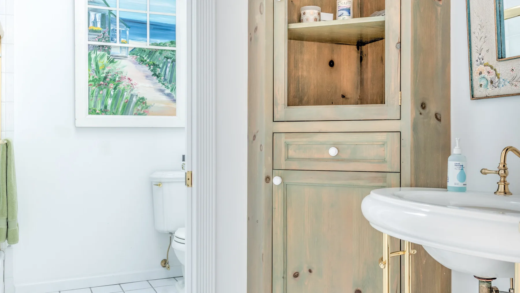 A bright bathroom with a white sink and a wooden cabinet.