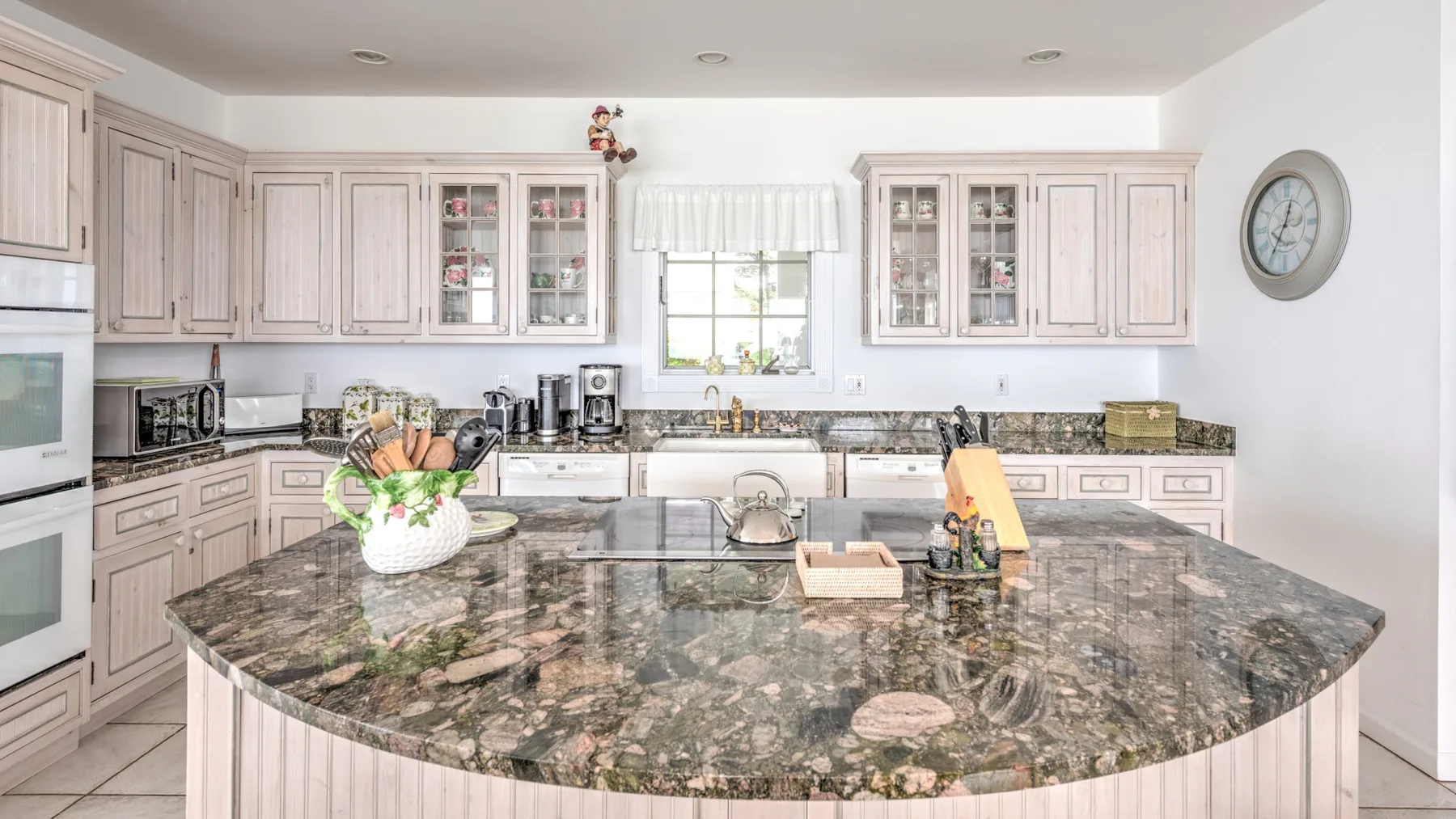A bright kitchen with pale cabinets and a large central island.