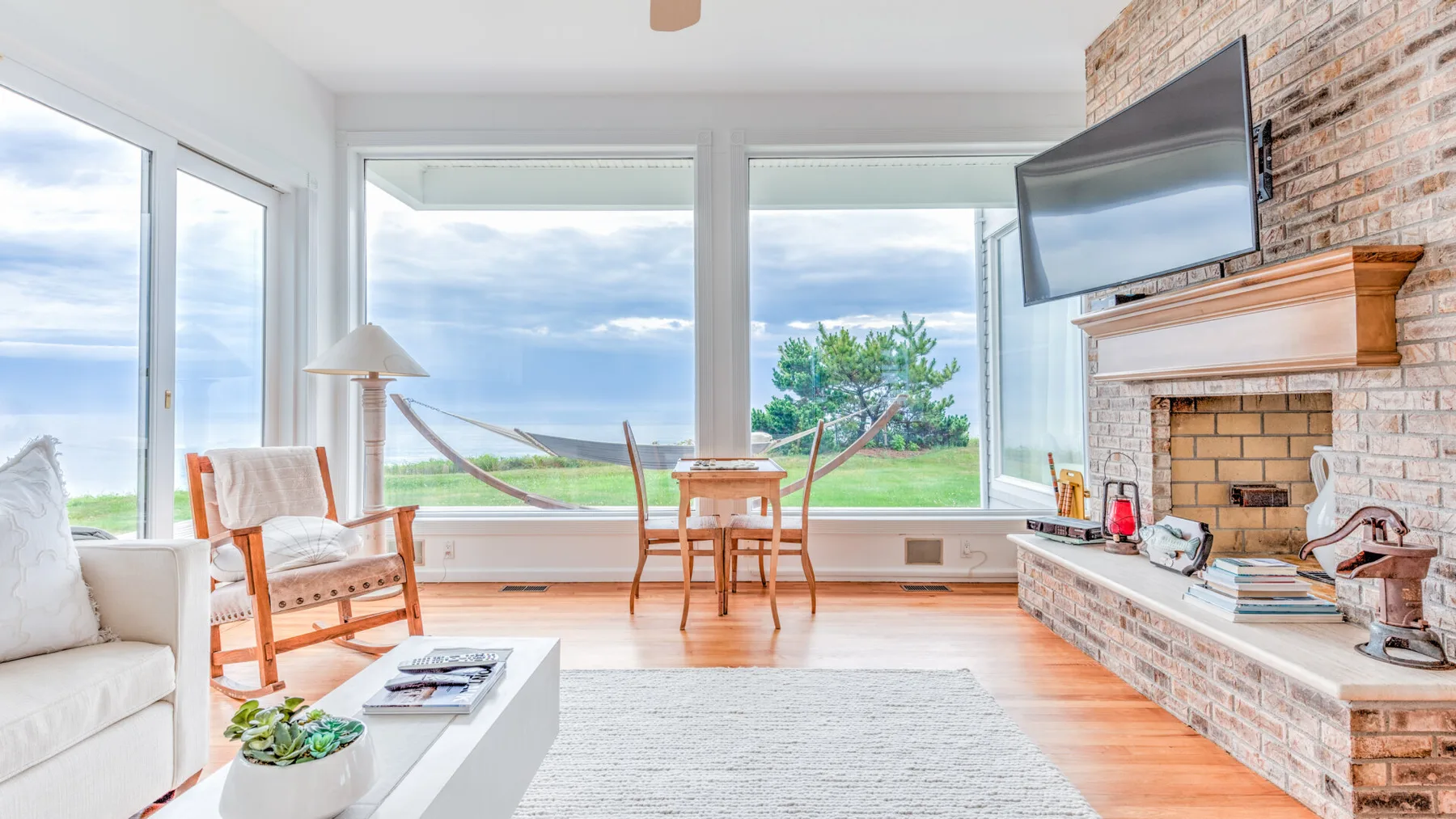 A bright living room with large windows overlooking a grassy landscape.