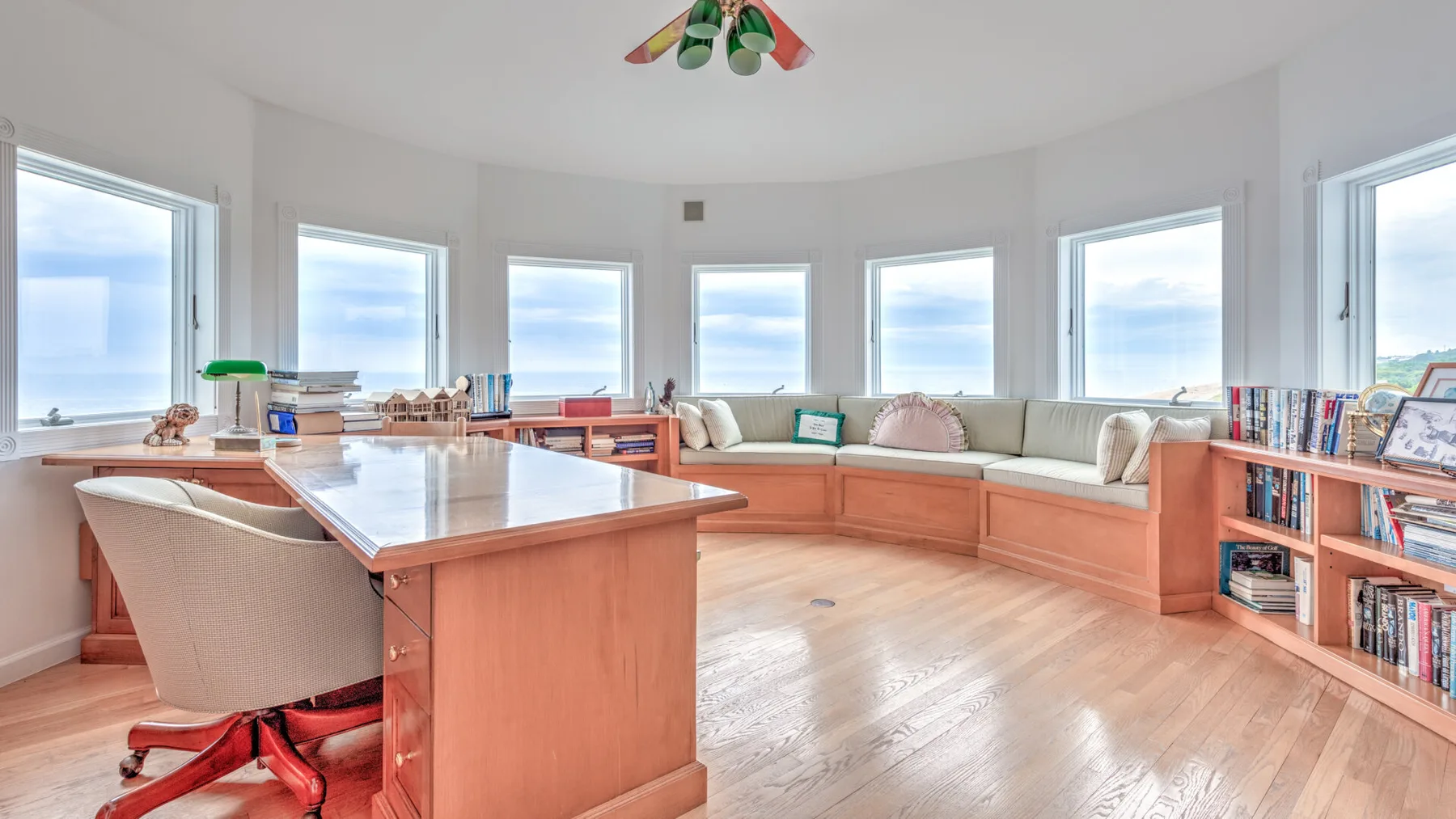 A bright room with a long built-in seating area and large windows.