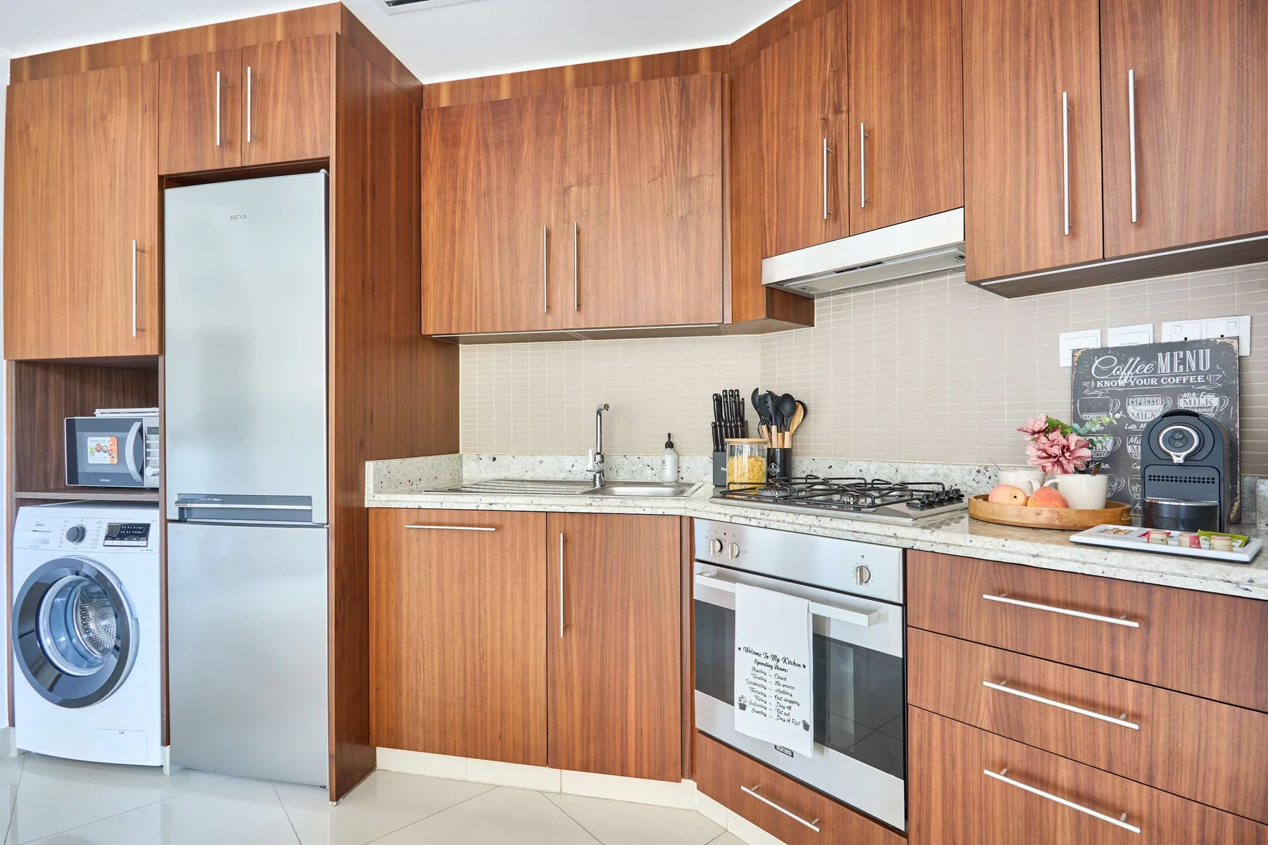 Una cocina con gabinetes de madera, un refrigerador y una encimera.