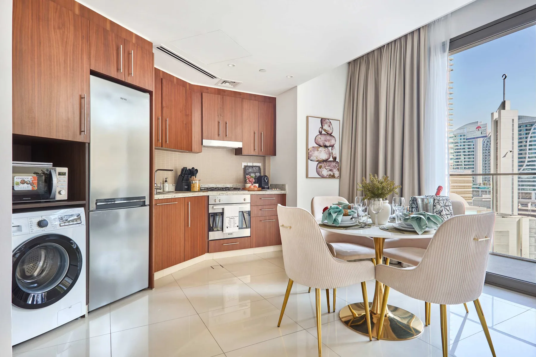 Cocina y comedor con gabinetes de madera, una mesa de comedor y ventanales.