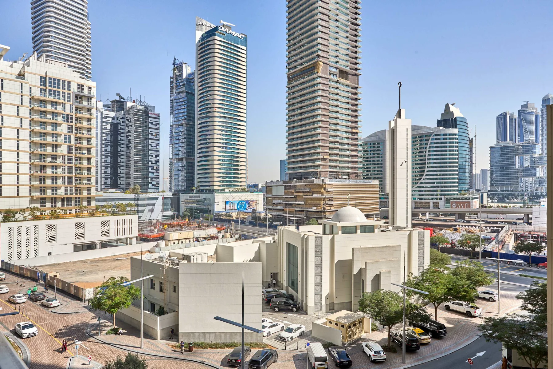 Un paisaje urbano de edificios modernos y altos sobre una calle concurrida.