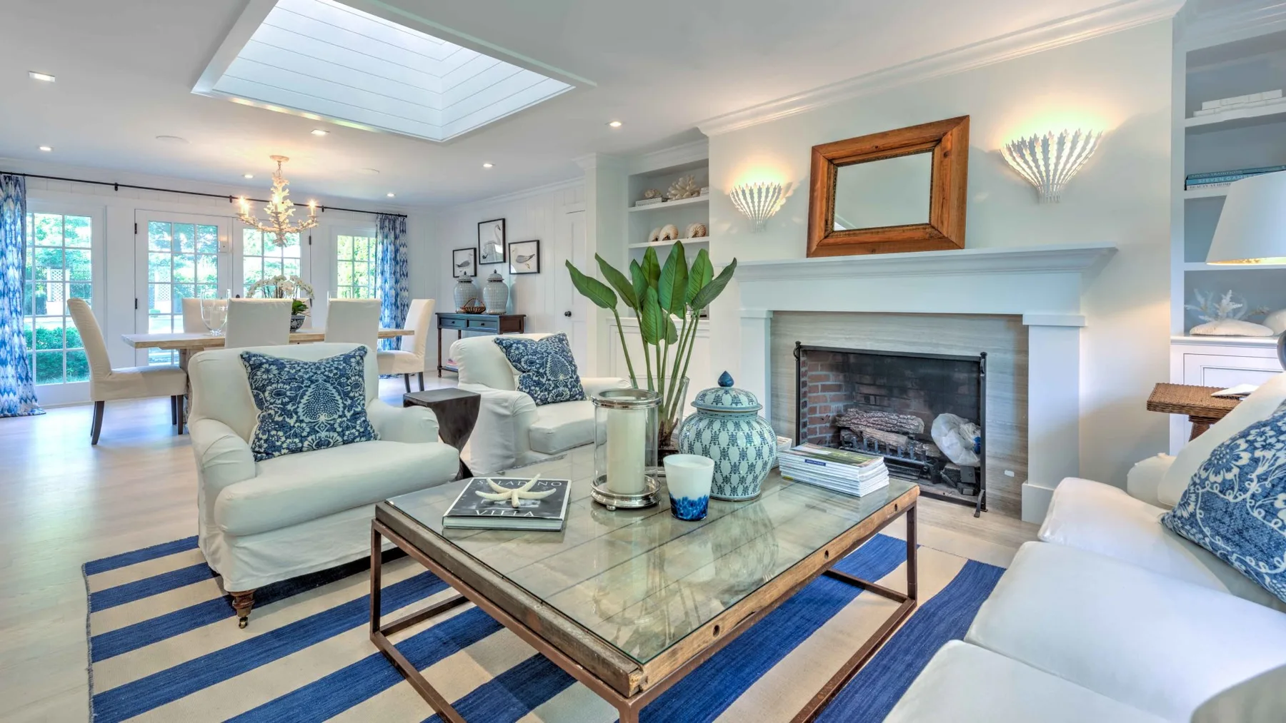 A bright living room with seating around a coffee table and a fireplace.