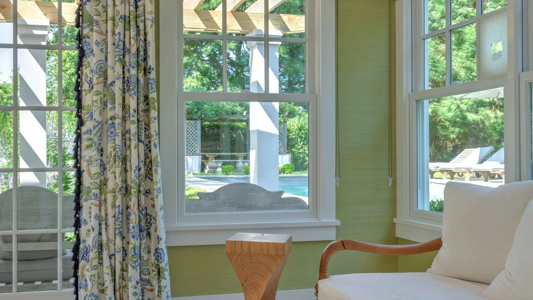A bright sitting area with large windows overlooking greenery.