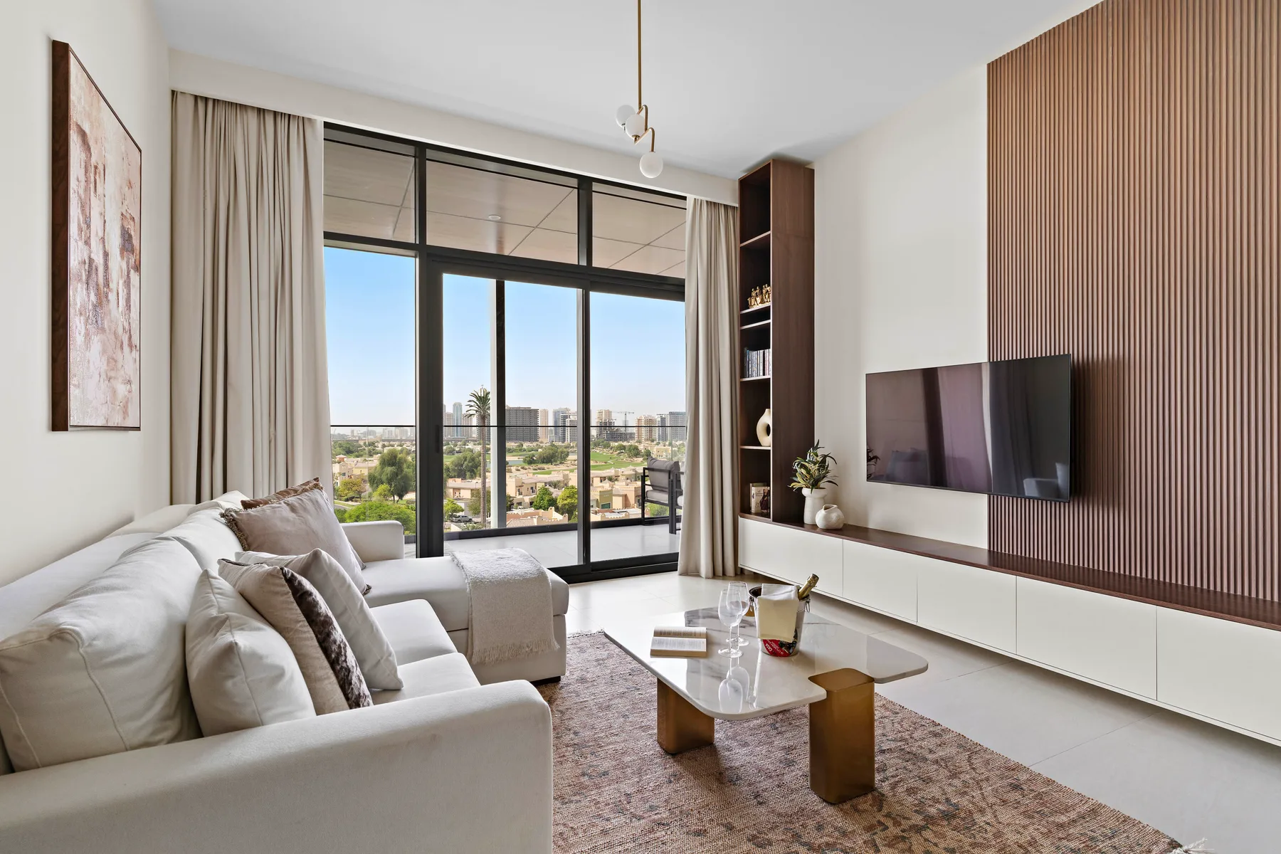 A bright living room with seating, a coffee table, and large windows.