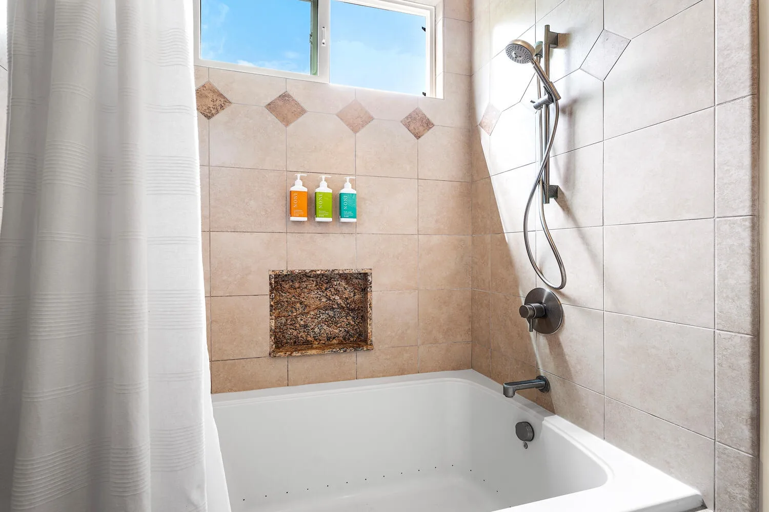 Un baño con azulejos, bañera, ducha y cortina.