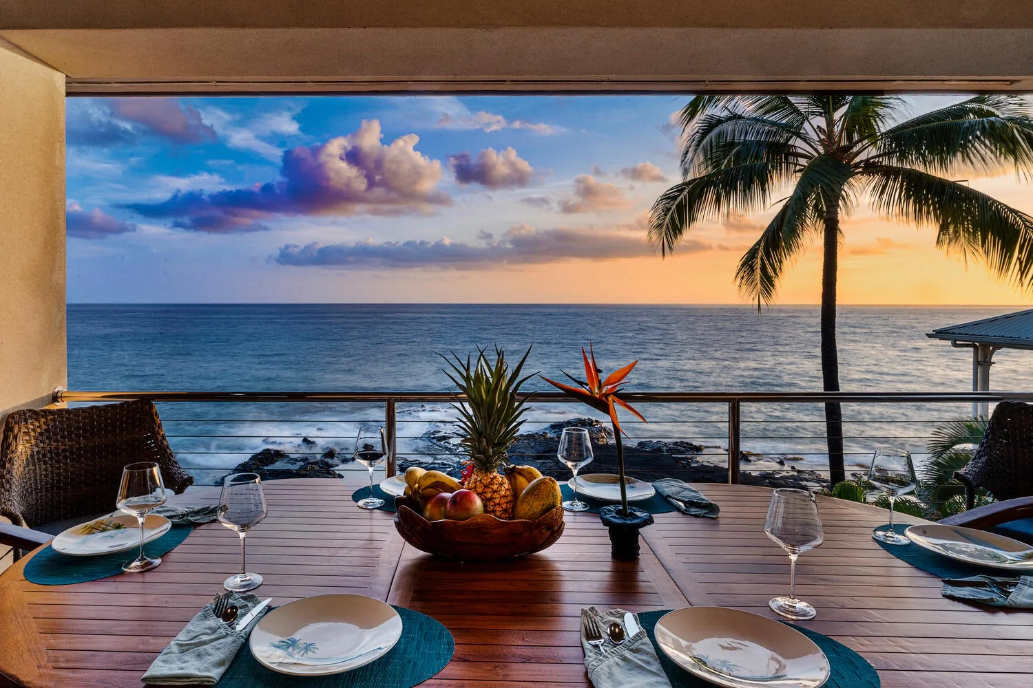Una mesa de comedor en una terraza junto al mar da al océano al atardecer.
