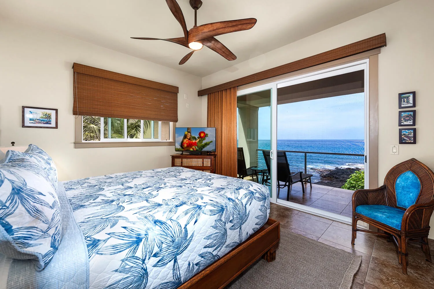 Un dormitorio con una cama junto a puertas corredizas de vidrio con vista al mar.