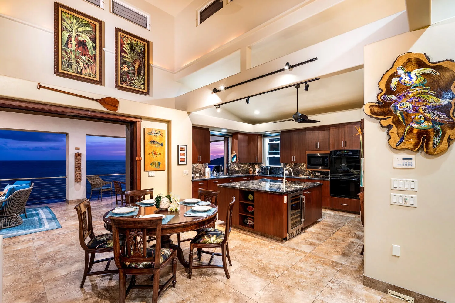Cocina y comedor abiertos con una isla central y una mesa.