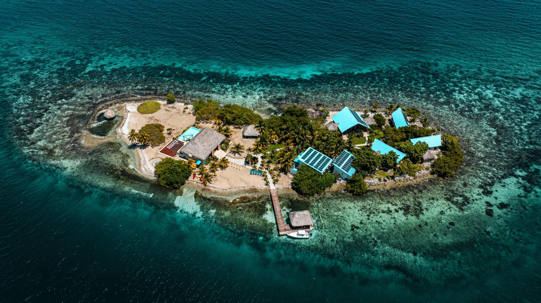 Aerial view of a small island surrounded by clear turquoise water.