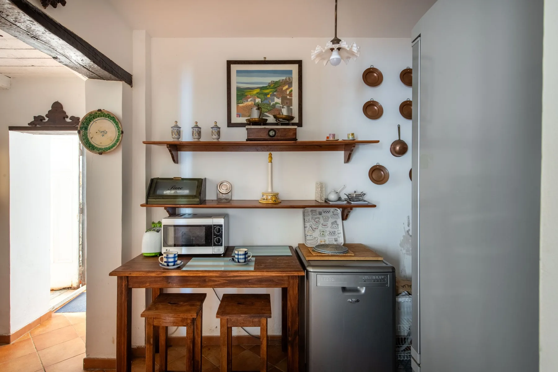 A compact kitchen and dining area with a wooden table and countertop appliances.