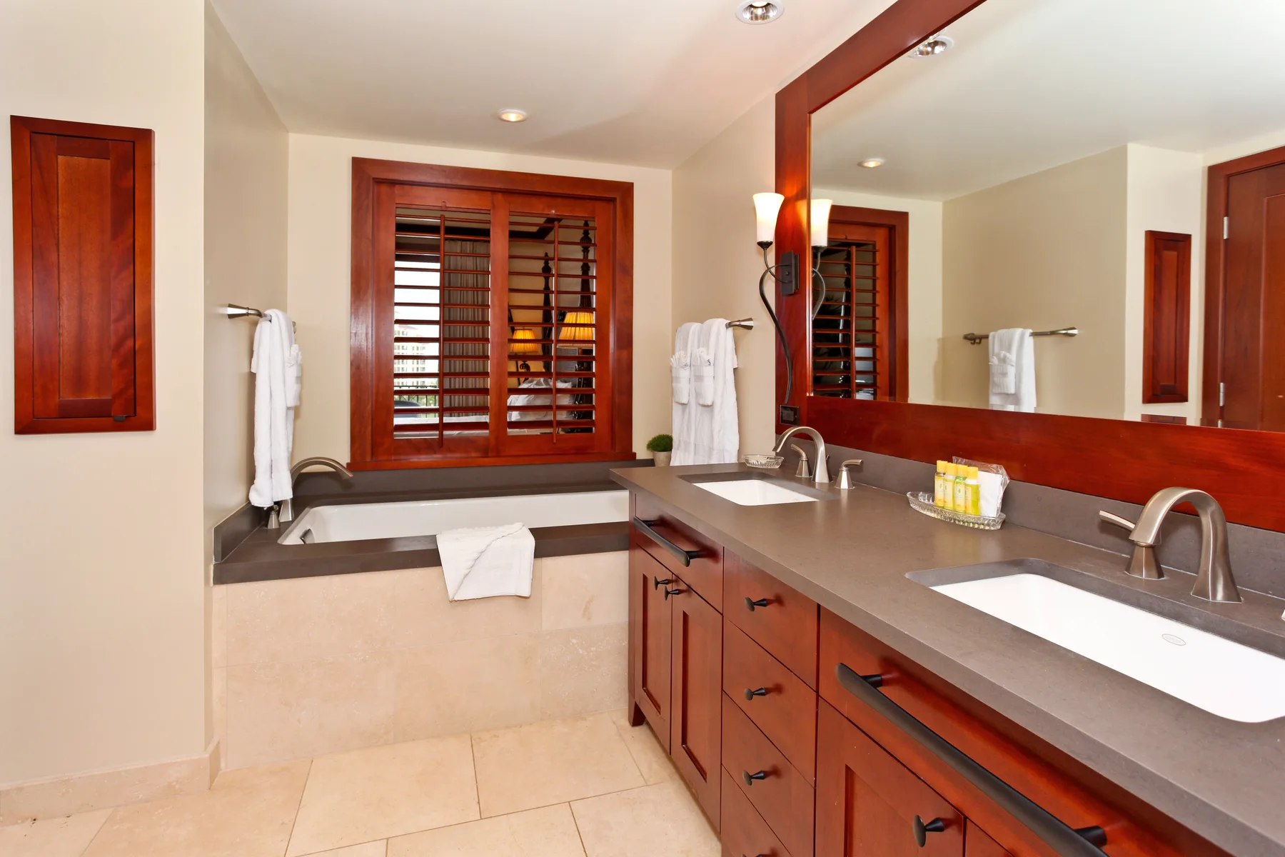 A bathroom with a long vanity, two sinks, and a large mirror.