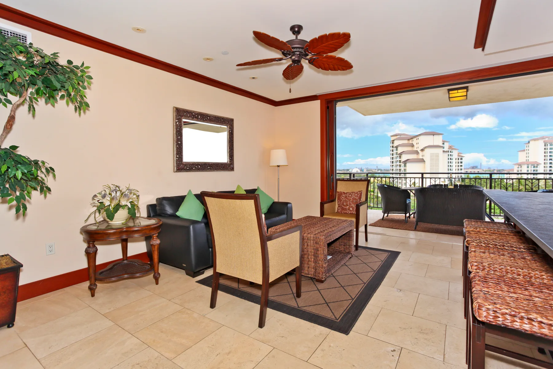 A furnished balcony seating area opens onto a view of nearby buildings and sky.