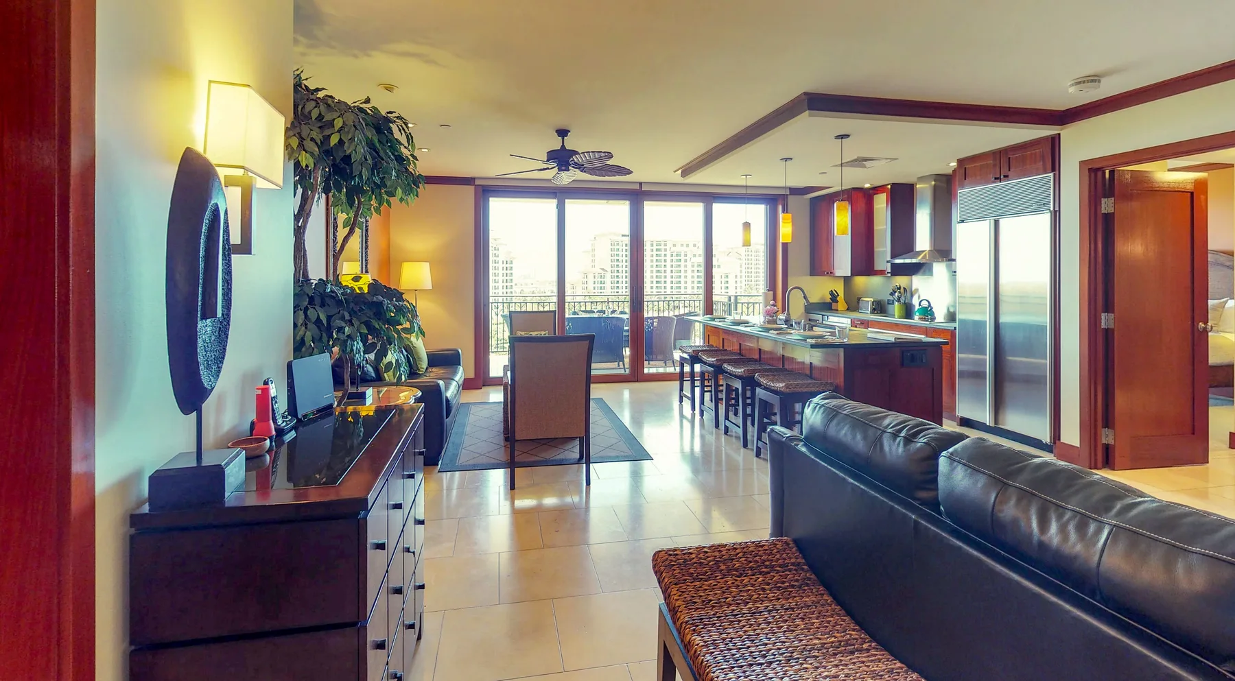 An open-plan living room and kitchen with seating and large windows.