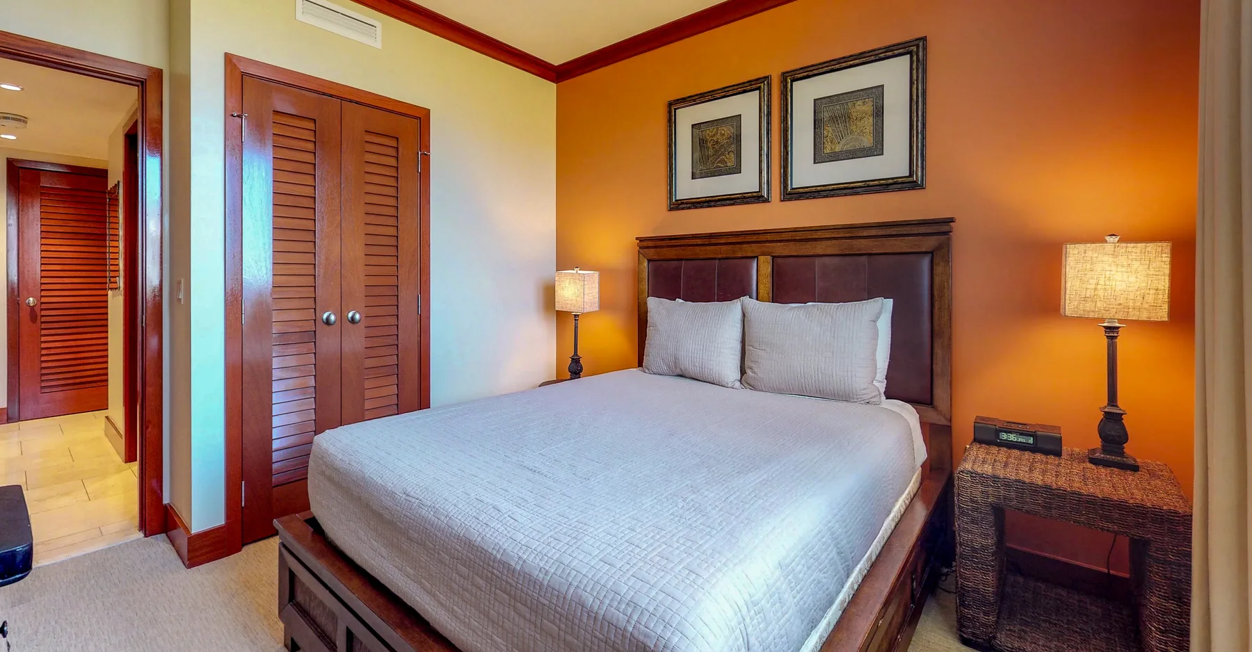 A bedroom with a large bed, wooden headboard, and matching bedside lamps.
