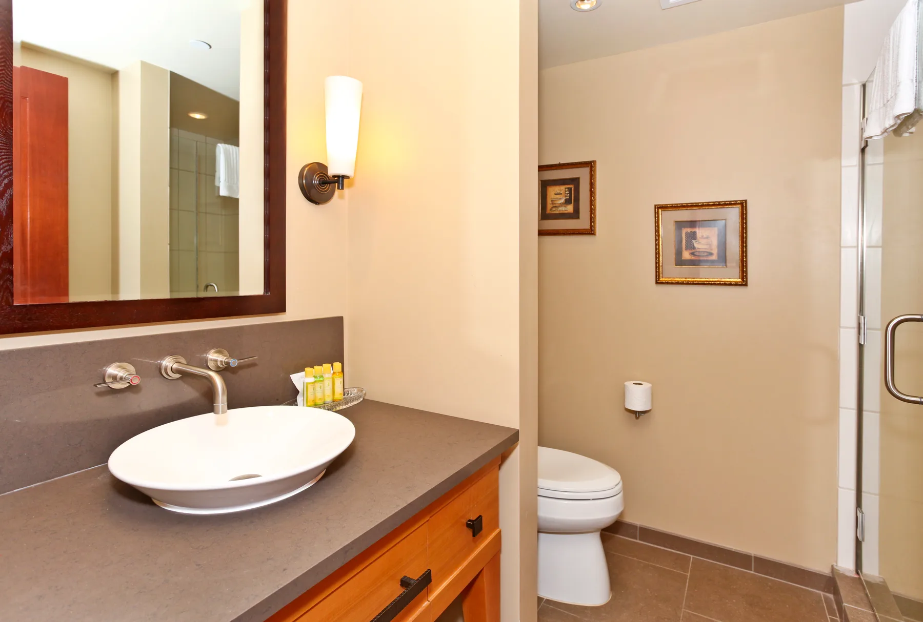 A bathroom with a sink, vanity, and toilet.