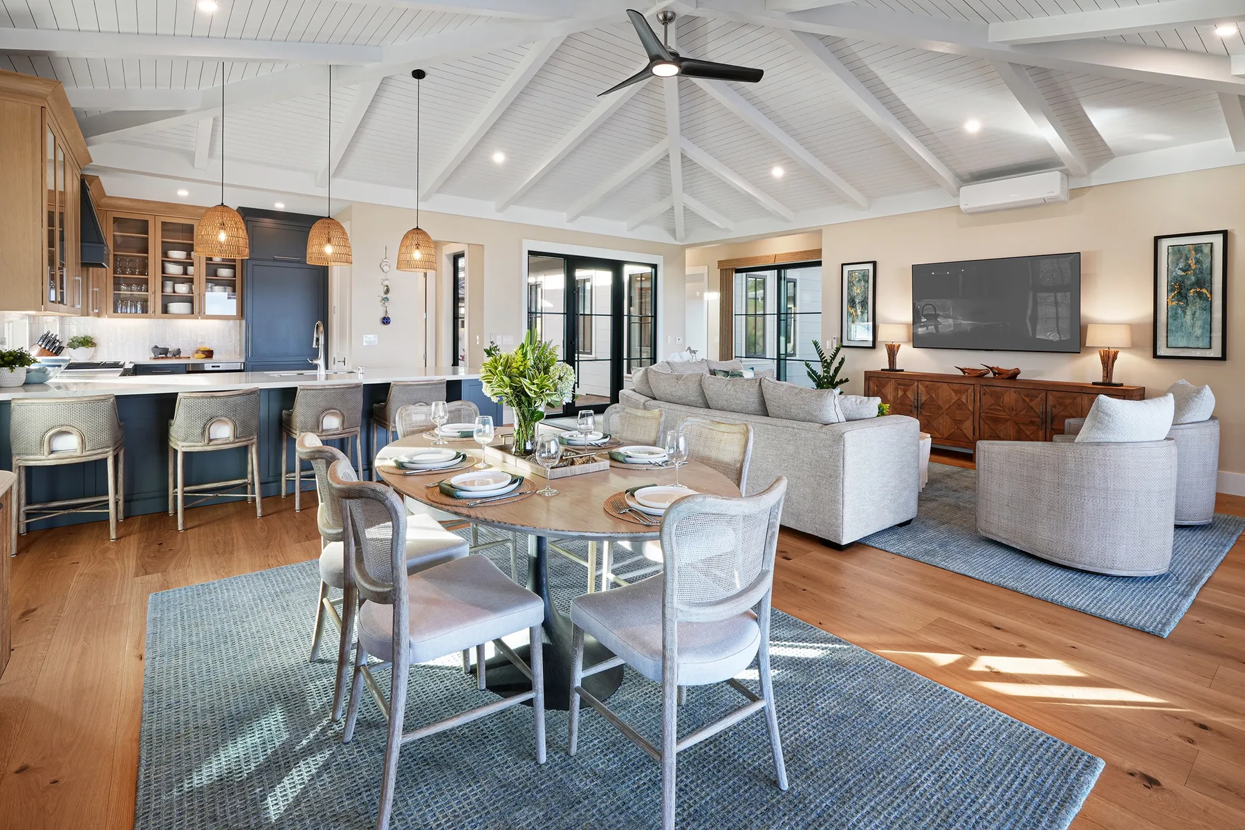 An open-plan living and dining area with a kitchen bar and seating.