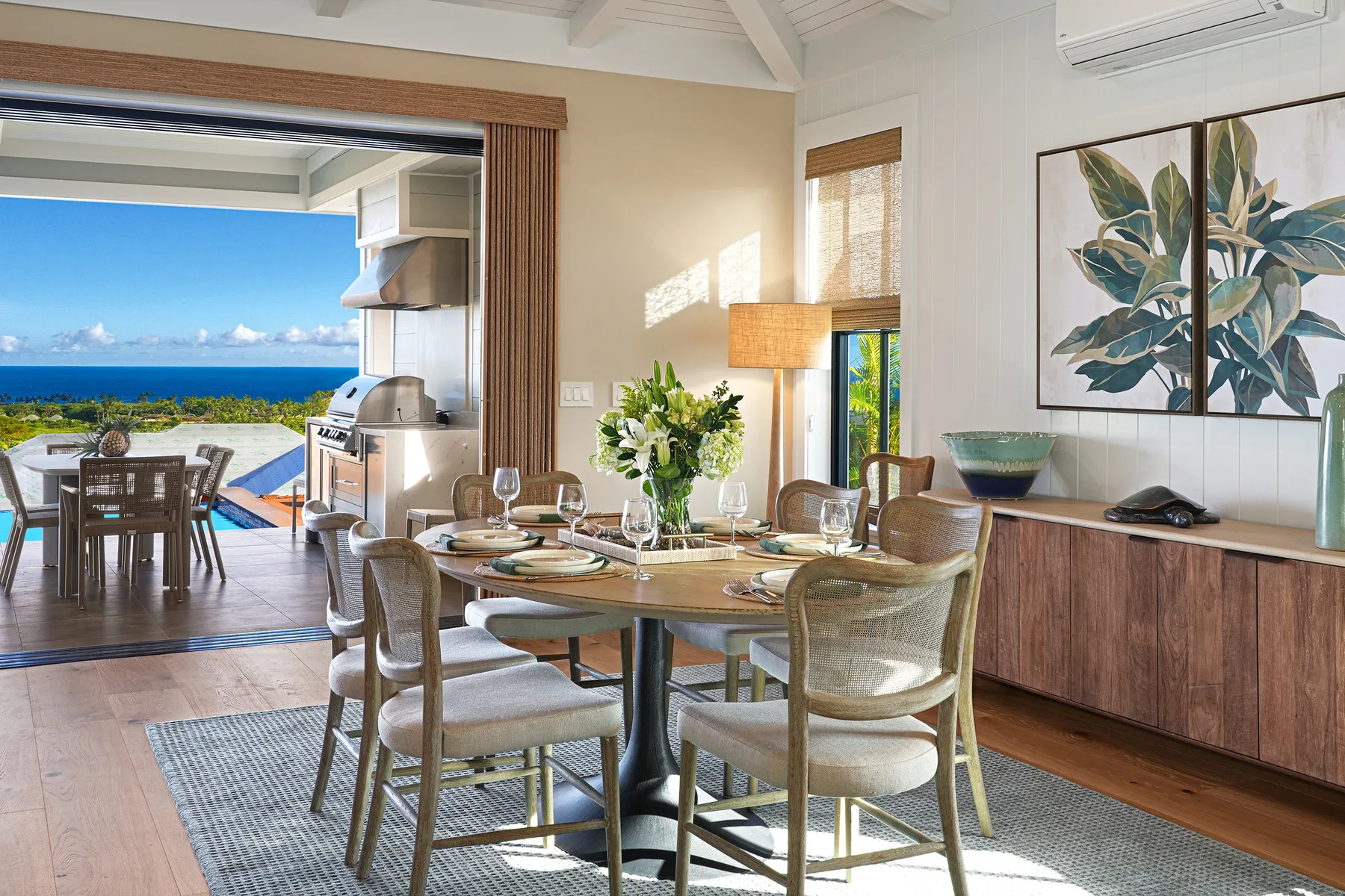 A dining area with a set table beside open doors leading to a patio.