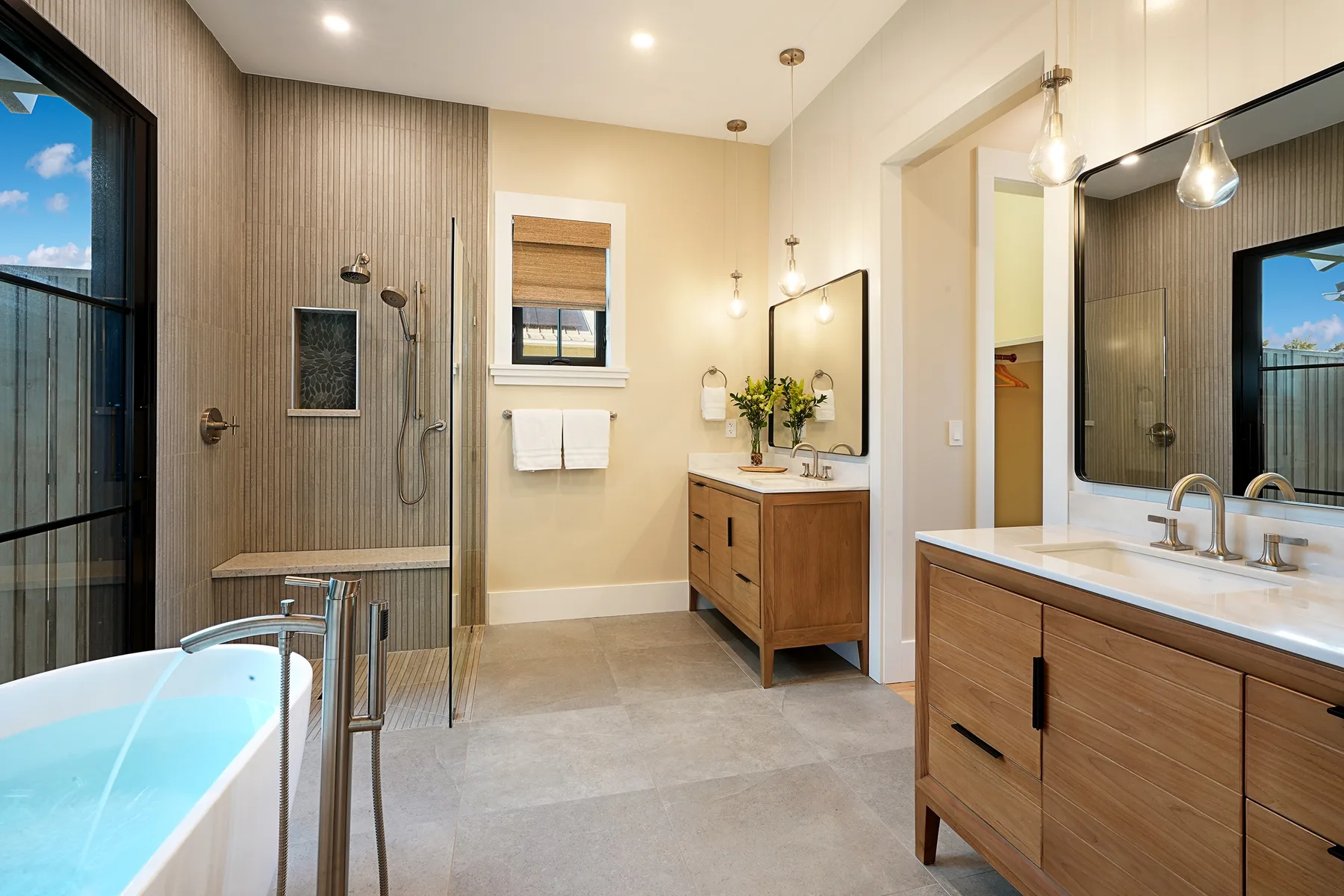 A bathroom with a bathtub, shower, and two wooden vanities.