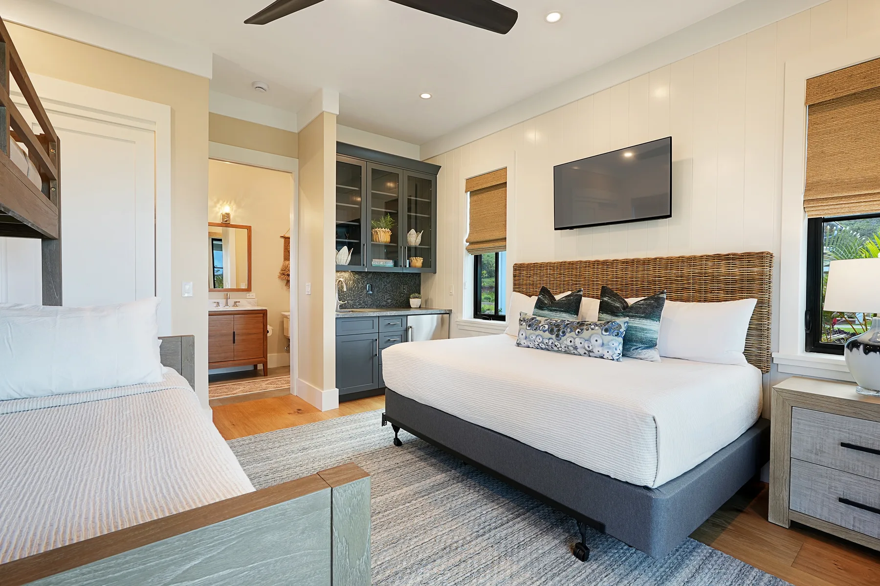 A bedroom with a large bed, a seating area, and a wall-mounted television.