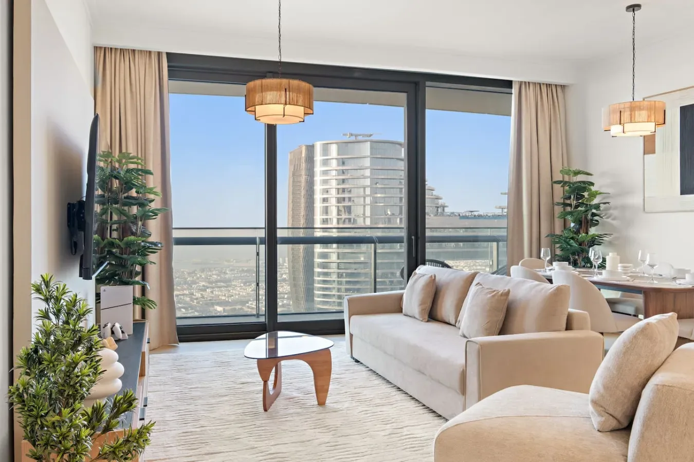A bright living room with a sofa and large windows overlooking nearby buildings.