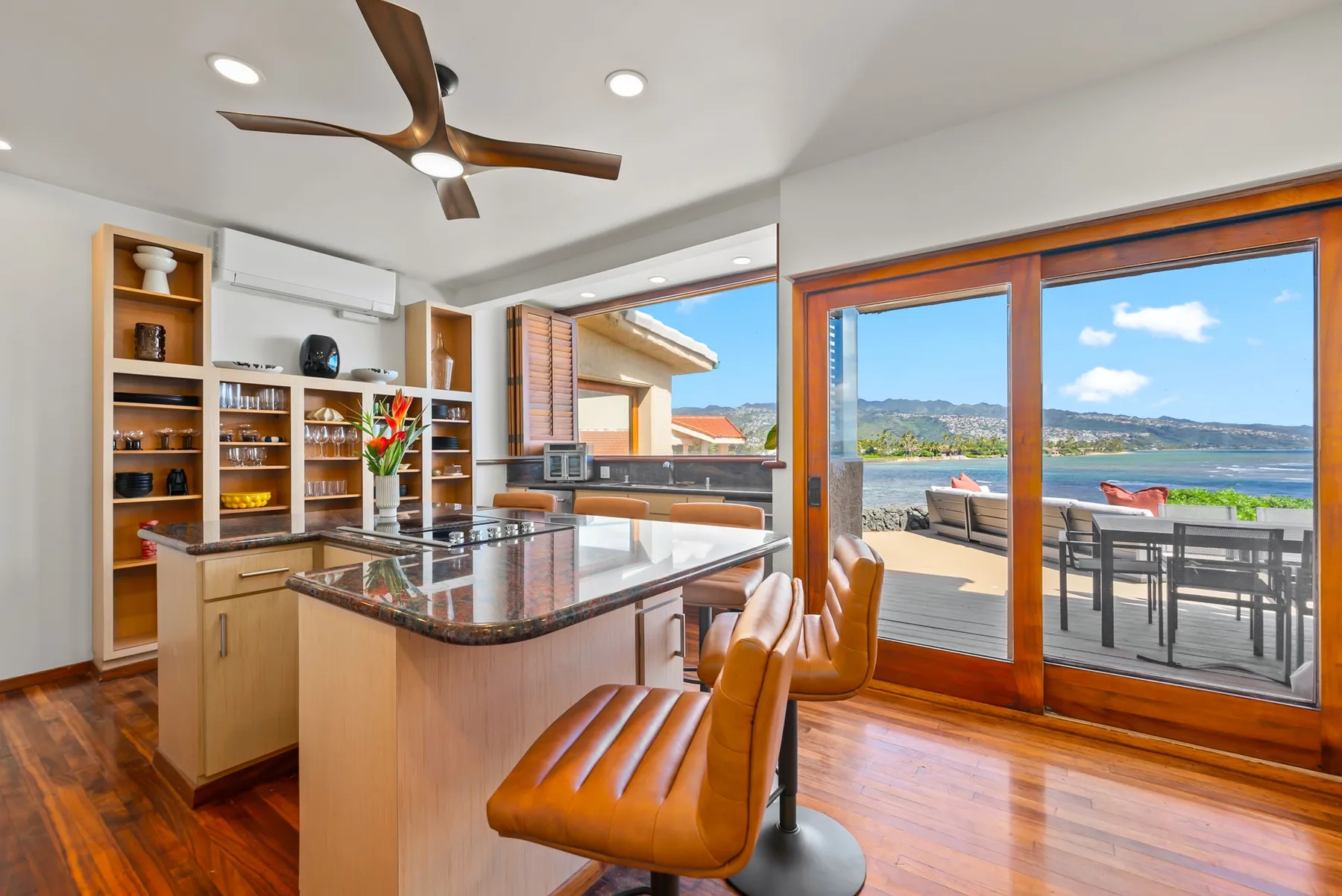 A bright kitchen opens onto a dining patio with views of the water.
