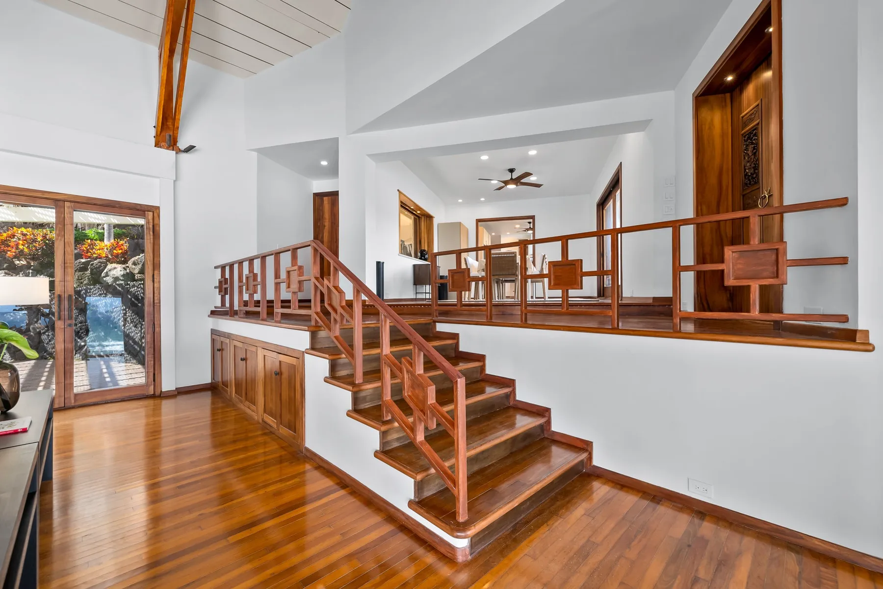A bright interior with a wooden staircase leading to a raised sitting area.